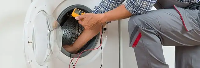 Dryer repair technician inspecting and repairing a clothes dryer in Madison, WI