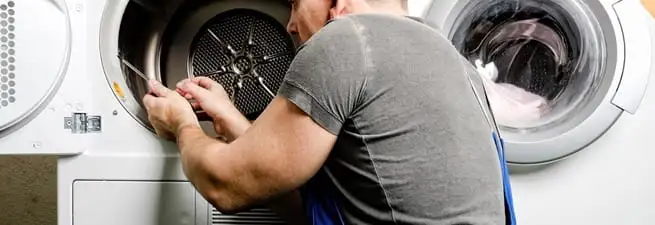 Dryer repair technician fixing a clothes dryer drum in Madison, WI