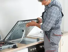 Appliance repair technician installing a built-in cooktop in Madison, WI