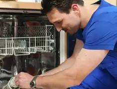 Dishwasher repair technician inspecting and servicing an open dishwasher in Madison, WI