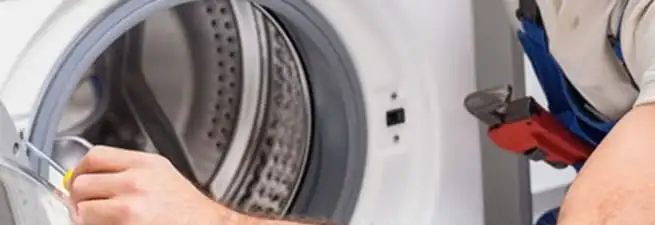 Appliance technician repairing a clothes dryer drum and internal parts in Madison, WI
