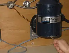 Garbage disposal repair technician tightening the mounting ring under a sink in Madison, WI