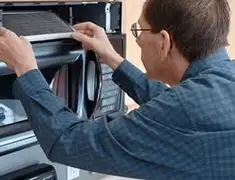 Appliance repair technician replacing a microwave vent filter in Madison, WI
