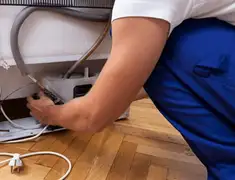 Appliance repair technician fixing refrigerator water line and connections in Madison, WI