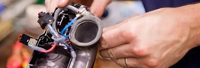 Vacuum repair technician reconnecting wiring and components in Madison, WI