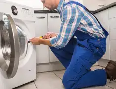 Washing machine repair technician servicing a front-load washer in Madison, WI