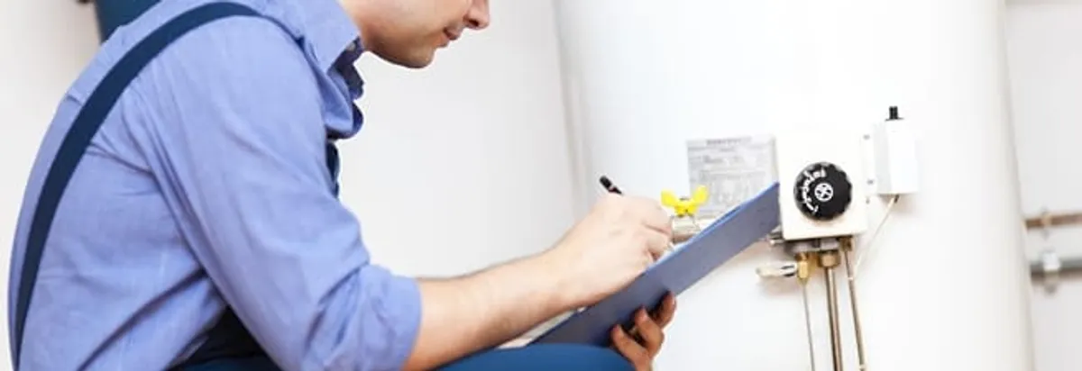 Water heater repair technician inspecting the unit and recording service notes in Madison, WI