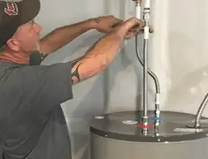 Water heater repair technician tightening supply line connections in Madison, WI