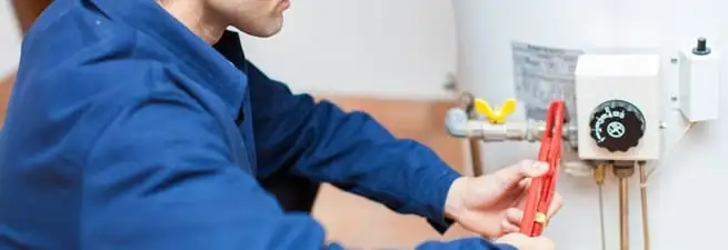 Water heater repair technician adjusting the temperature control and gas valve in Madison, WI